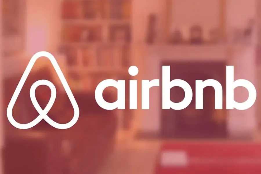 Logo Airbnb sur fond de salon flou, illustrant la sous-location non autorisée d'un logement au Maroc